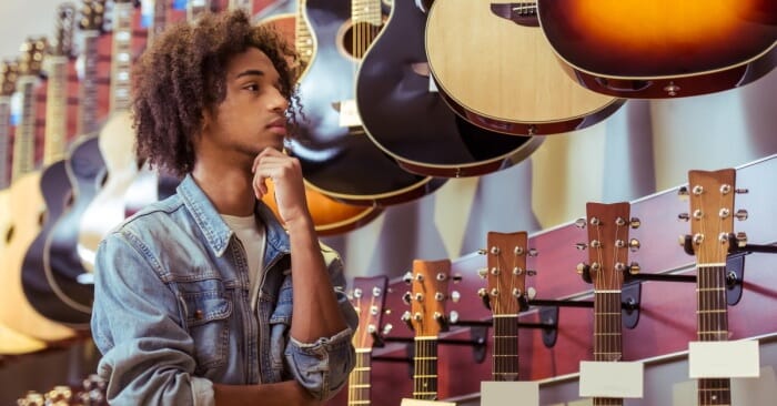 Man looking at musical instruments in pawn shop