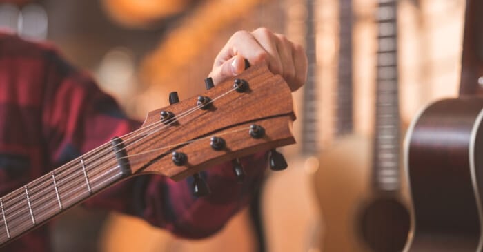 Musician adjusting his guitar