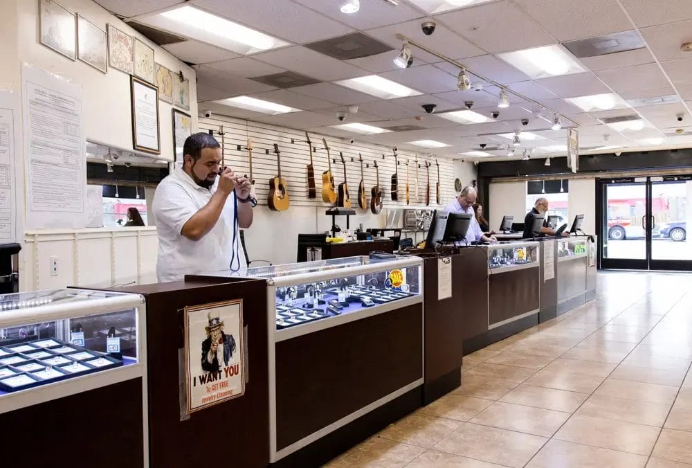 A pawn shop employee focused on his work